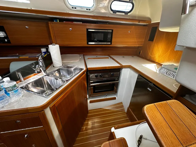 Slide: The Image of Interior of Catalina 385 yacht kitchen, 2017 model, featuring wood finish and modern appliances. - 15