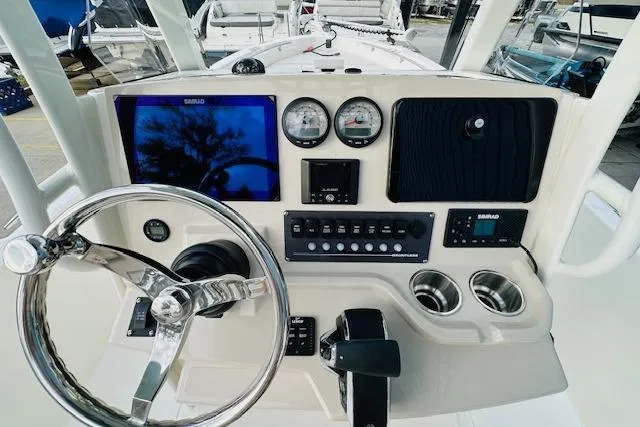 Slide: The Image of 2025 Boston Whaler 250 Dauntless boat dashboard with steering wheel and navigation instruments. - 16