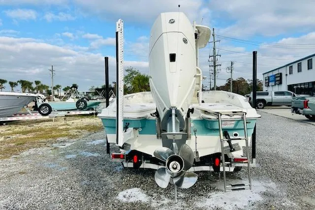 Slide: The Image of 2025 Boston Whaler 250 Dauntless boat, rear view, parked on gravel lot. - 2