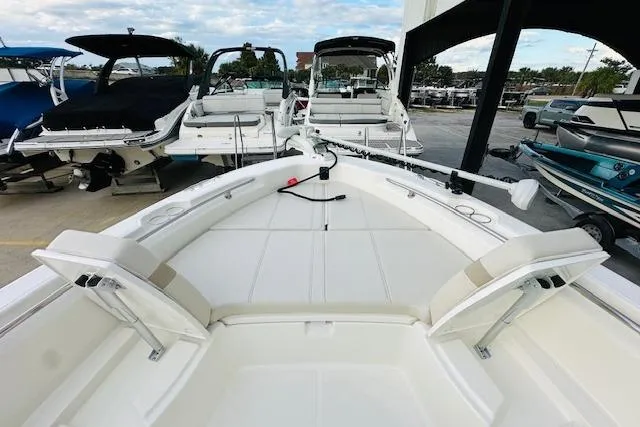 Slide: The Image of 2025 Boston Whaler 250 Dauntless boat interior with seating and storage, docked at a marina. - 20