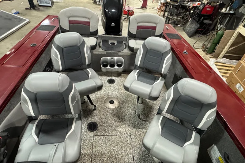 Slide: The Image of 2014 Tracker Targa V-18 Combo boat interior with six gray seats in a workshop. - 7