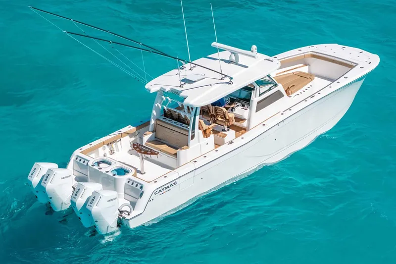 Slide: The Image of Manufacturer Provided Image: 2025 Caymas 44 CT boat cruising on clear turquoise water. - 1