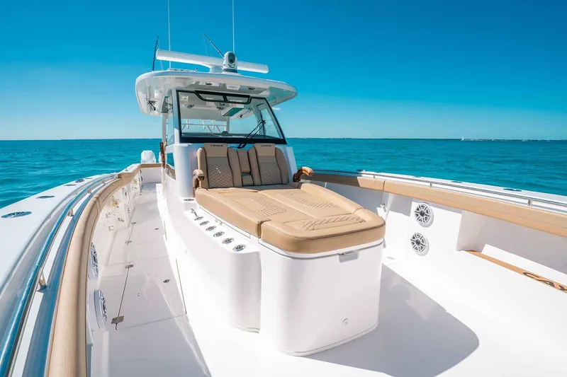 Slide: The Image of Manufacturer Provided Image: 2025 Caymas 44 CT boat on clear blue water, featuring luxurious seating and sleek design. - 4