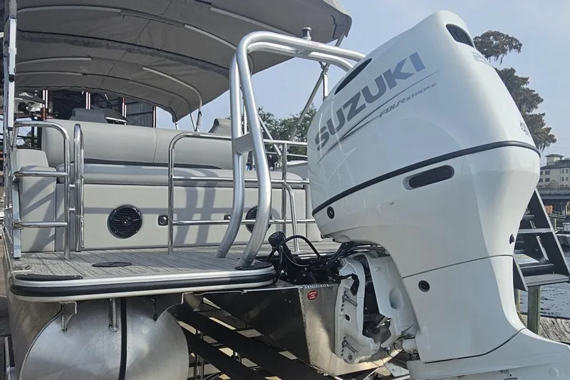 Slide: The Image of 2026 Bentley Pontoons Legacy 223 Swingback with Suzuki outboard motor, docked at marina. - 4