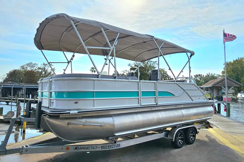 Slide: The Image of 2026 Bentley Pontoons Legacy 223 Swingback on trailer by waterfront dock. - 6