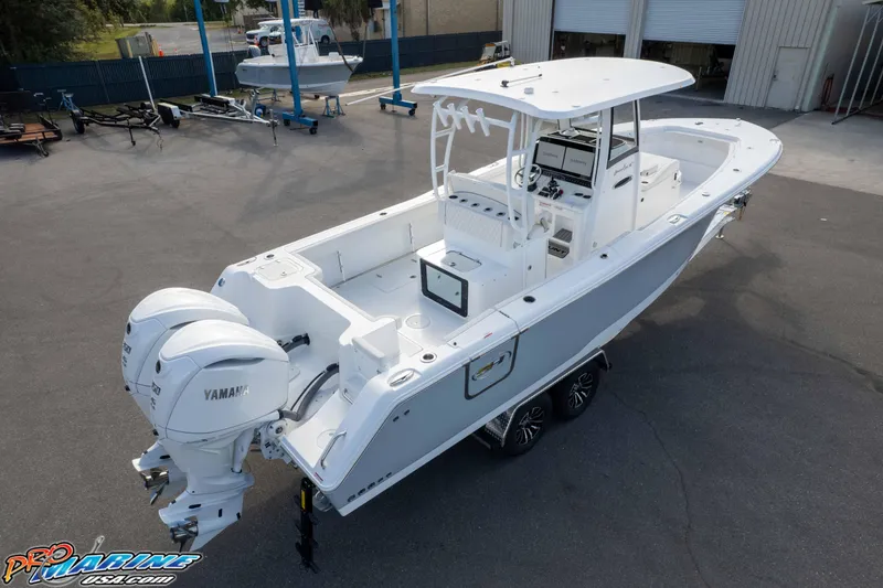Slide: The Image of 2026 Sea Hunt Gamefish 30 Coffin Box boat with dual Yamaha engines, parked outdoors. - 13