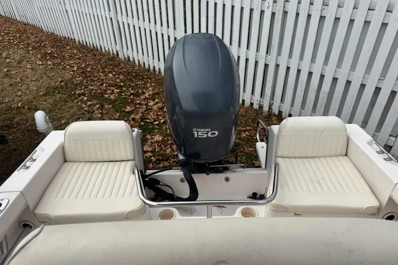 Slide: The Image of 2008 Grady White 180 Sportsman boat with Yamaha 150 engine, white seating, near a fence. - 4