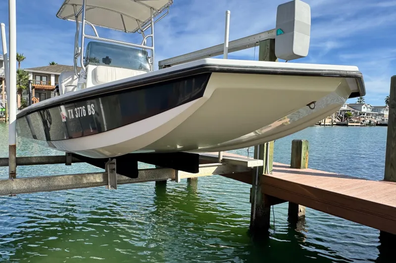 Slide: The Image of 2012 Majek Illusion 226 boat on lift by dock, clear water, sunny day. - 4