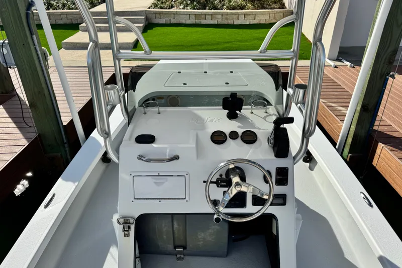 Slide: The Image of 2012 Majek Illusion 226 boat console with steering wheel and gauges, docked near wooden pier. - 8