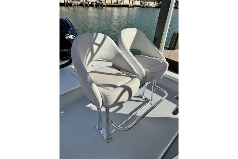 Slide: The Image of Two cushioned boat seats on a 2012 Majek Illusion 226, near water. - 13