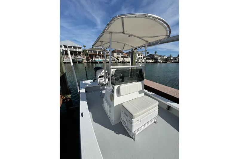 Slide: The Image of 2012 Majek Illusion 226 boat with T-top, docked by waterfront homes. - 14