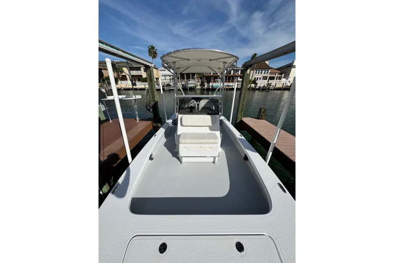 Slide: The Image of 2012 Majek Illusion 226 boat docked, featuring spacious deck and canopy under clear skies. - 15