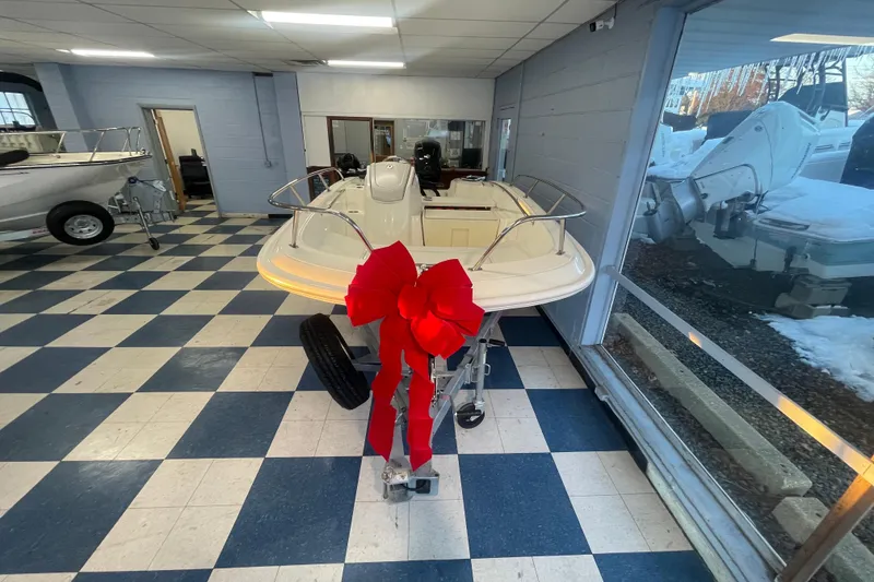Slide: The Image of 2026 Boston Whaler 160 Super Sport with red bow in showroom. - 3