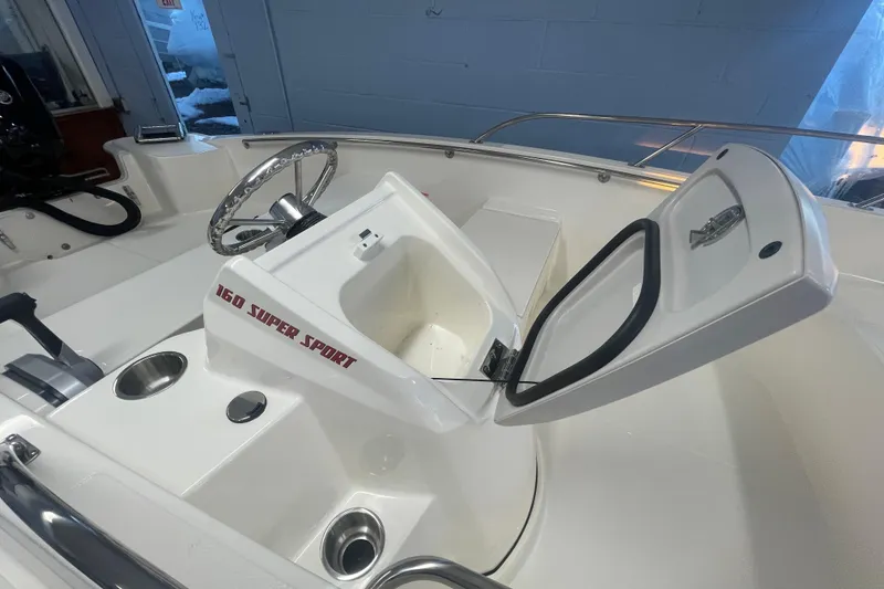 Slide: The Image of Boston Whaler 160 Super Sport 2026, open storage compartment in cockpit. - 7
