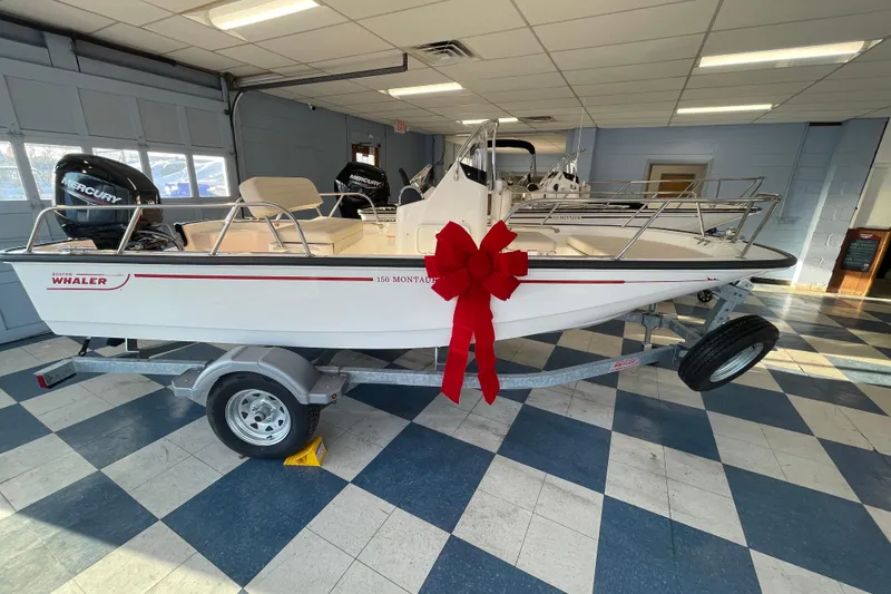 The Image of 2026 Boston Whaler 150 Montauk with red bow in showroom. - 0