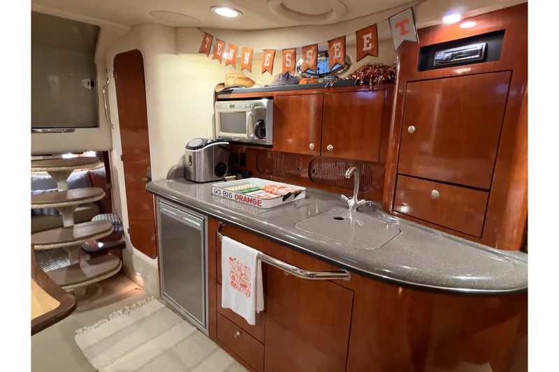 Slide: The Image of 2007 Sea Ray 340 Sundancer interior kitchen with wood cabinets and modern appliances. - 15