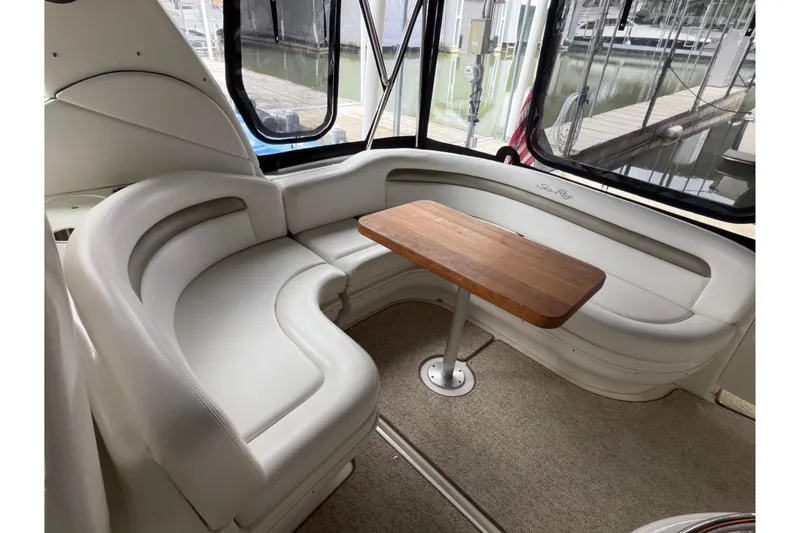 Slide: The Image of 2007 Sea Ray 340 Sundancer interior with curved seating and wooden table. - 7