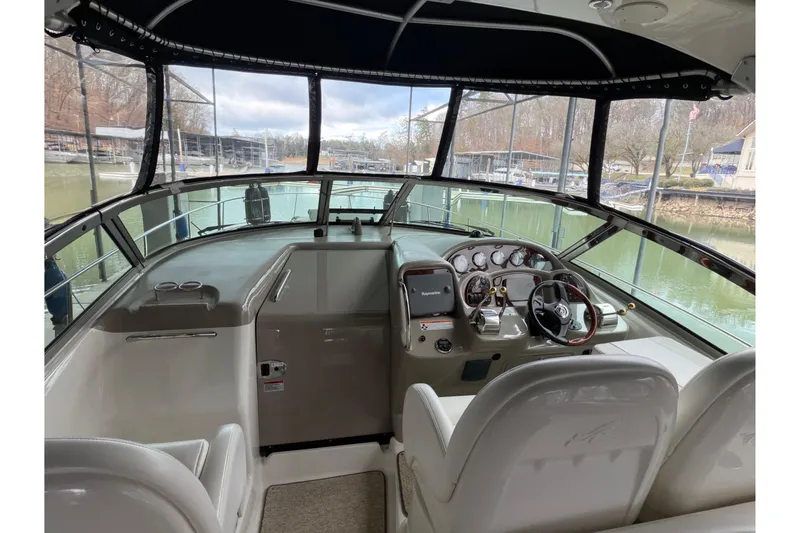 Slide: The Image of 2007 Sea Ray 340 Sundancer cockpit with steering wheel and control panel, docked at marina. - 9