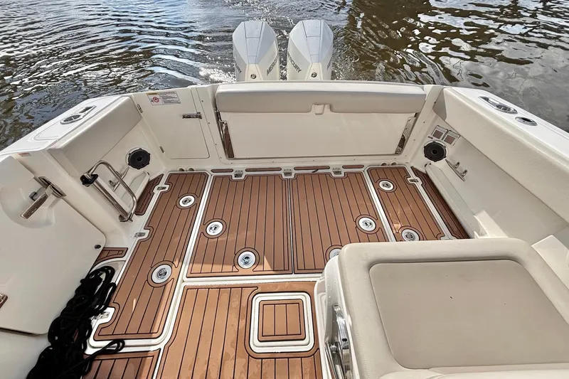 Slide: The Image of 2021 Boston Whaler 320 Vantage boat deck with teak flooring and twin engines. - 13