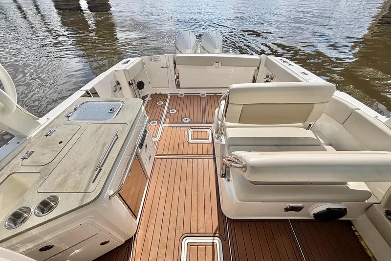 Slide: The Image of 2021 Boston Whaler 320 Vantage boat interior with seating and wooden deck. - 14