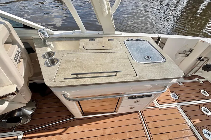 Slide: The Image of 2021 Boston Whaler 320 Vantage boat kitchen area with sink and storage. - 15