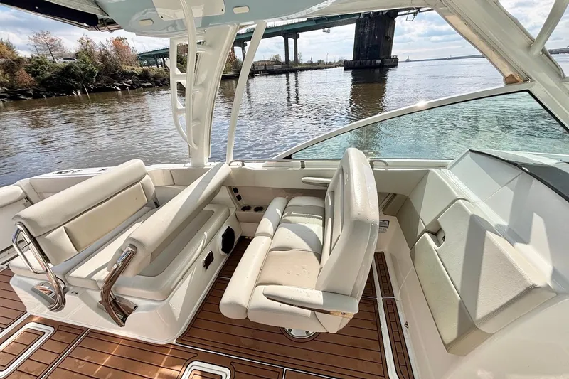 Slide: The Image of 2021 Boston Whaler 320 Vantage boat interior with seating, near a bridge on calm water. - 17