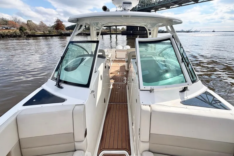 Slide: The Image of 2021 Boston Whaler 320 Vantage boat on calm water under a bridge. - 19