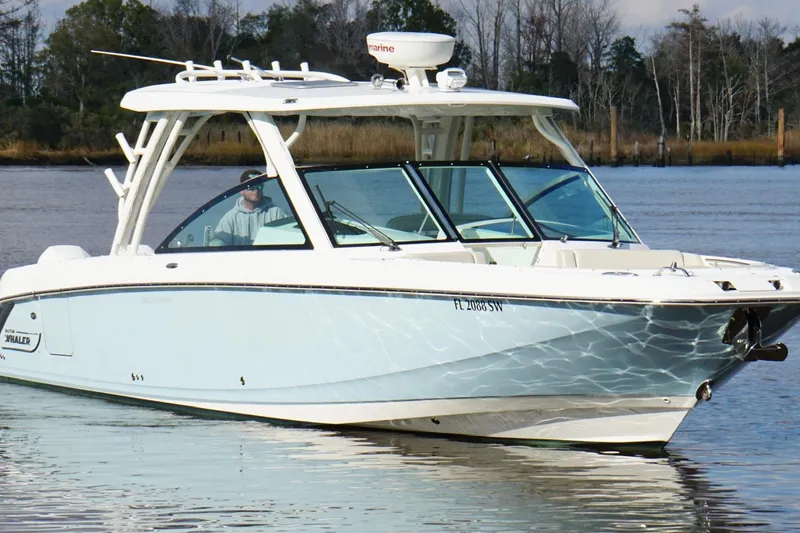 Slide: The Image of 2021 Boston Whaler 320 Vantage boat cruising on a calm river. - 6