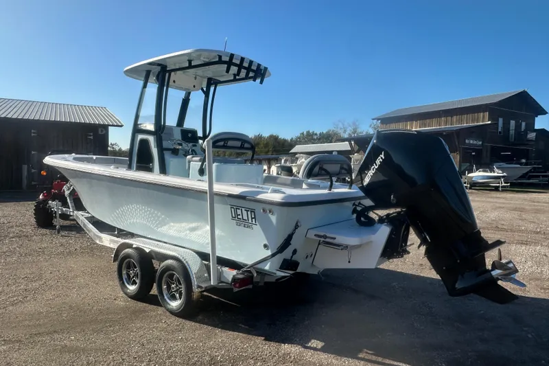 Slide: The Image of 2026 Delta Boatworks Delta D245 on trailer, featuring Mercury outboard motor, parked outdoors. - 3