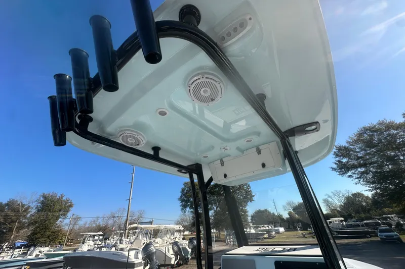 Slide: The Image of 2026 Delta Boatworks Delta D245 T-top with rod holders and speakers, under clear blue sky. - 31