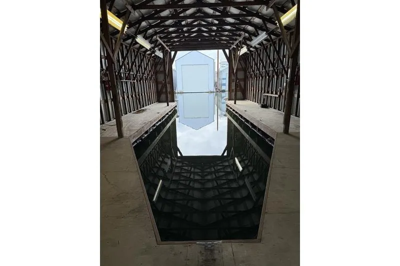 Slide: The Image of Interior of a 2005 Larson Boat House, showcasing a reflective water surface. - 7