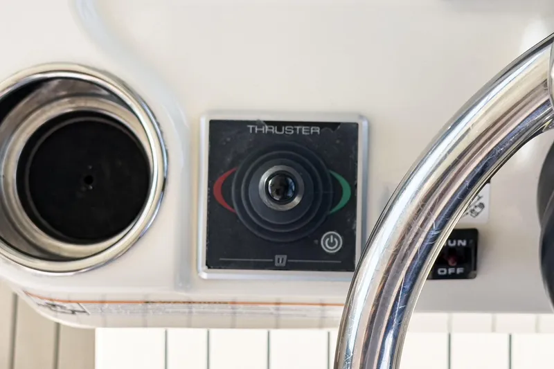 Slide: The Image of Control panel of 2023 Scout 530 LXF boat featuring thruster joystick and steering wheel. - 59