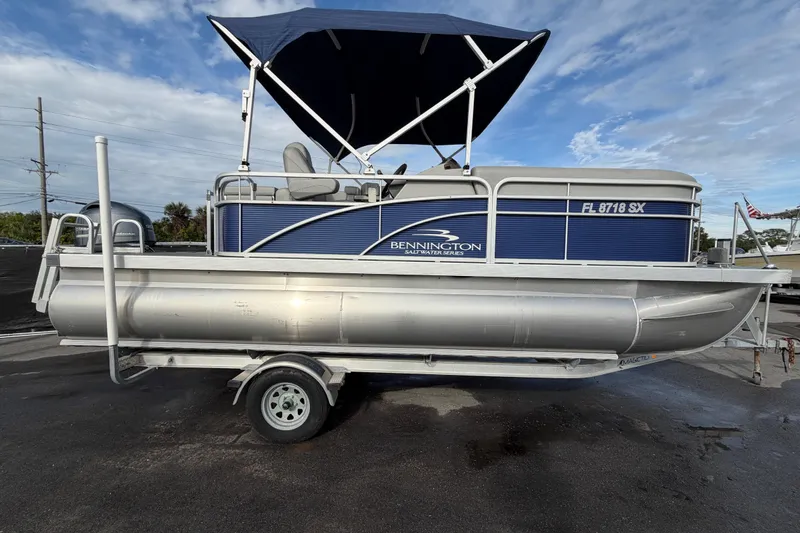 Slide: The Image of 2021 Bennington 20 SV pontoon boat with blue canopy on trailer. - 1