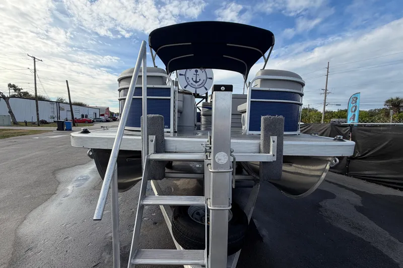 Slide: The Image of 2021 Bennington 20 SV pontoon boat on trailer, blue and white design, outdoor setting. - 11