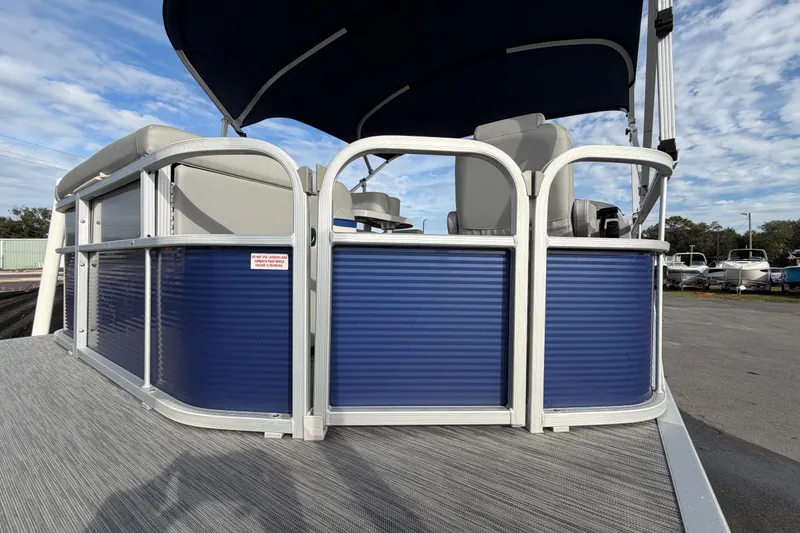 Slide: The Image of 2021 Bennington 20 SV pontoon boat with blue paneling and canopy, parked outdoors. - 15