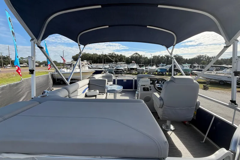 Slide: The Image of 2021 Bennington 20 SV pontoon boat interior with seating and canopy, displayed outdoors. - 16