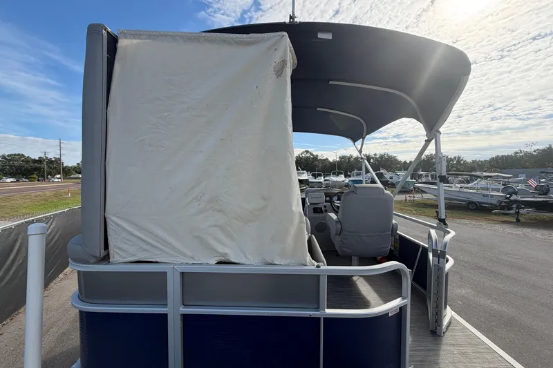 Slide: The Image of 2021 Bennington 20 SV pontoon boat with canopy, parked outdoors under a cloudy sky. - 17