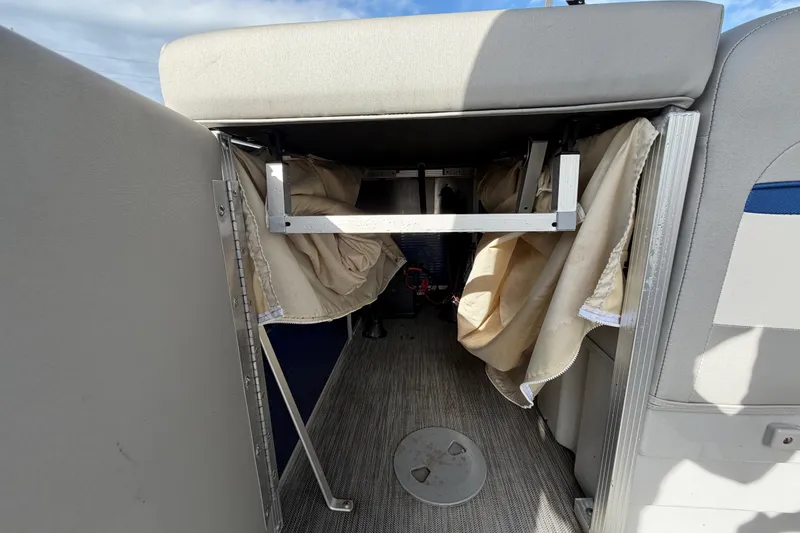 Slide: The Image of 2021 Bennington 20 SV boat interior with storage compartment and beige curtains. - 20