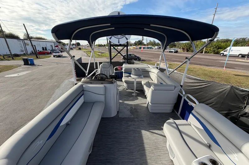Slide: The Image of 2021 Bennington 20 SV pontoon boat with spacious seating and canopy, parked outdoors. - 38