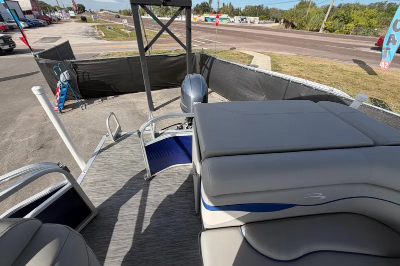 Slide: The Image of 2021 Bennington 20 SV pontoon boat with seating and outboard motor, parked outdoors. - 46