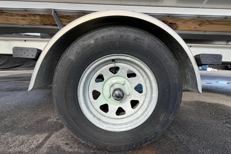 Slide: The Image of Trailer wheel of a 2021 Bennington 20 SV boat on pavement. - 52