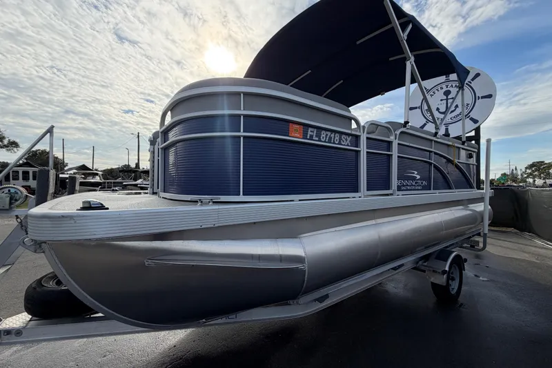 Slide: The Image of 2021 Bennington 20 SV pontoon boat on trailer under a cloudy sky. - 9