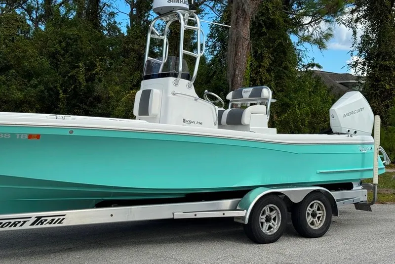 Slide: The Image of 2021 BlackJack 256 Coastal boat on trailer, featuring a sleek turquoise hull. - 13