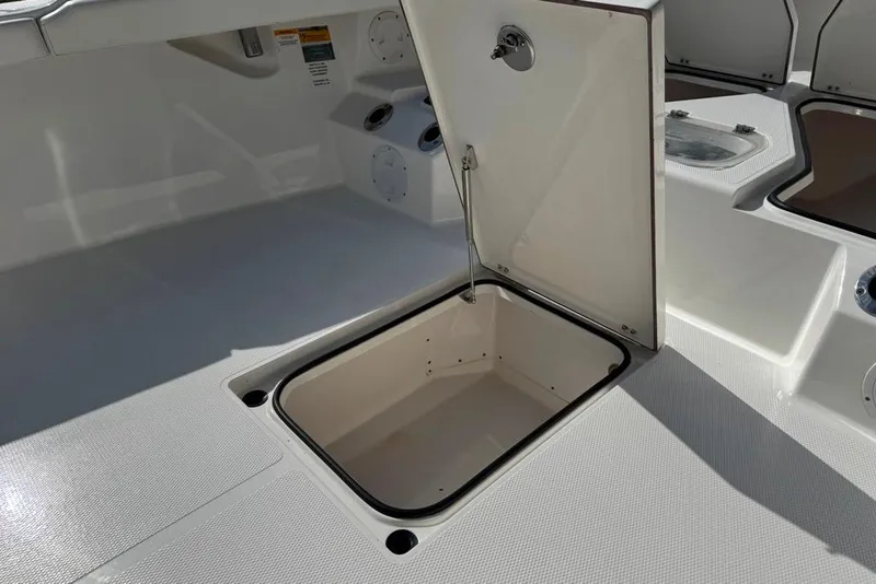Slide: The Image of Open storage compartment on a 2021 BlackJack 256 Coastal boat deck. - 18