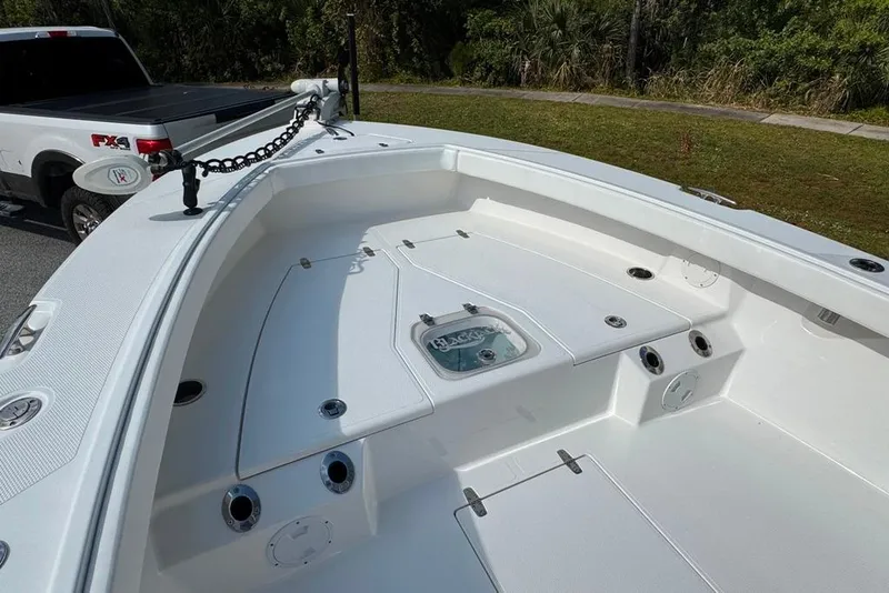 Slide: The Image of 2021 BlackJack 256 Coastal boat interior with fishing rod holders and storage compartments. - 20