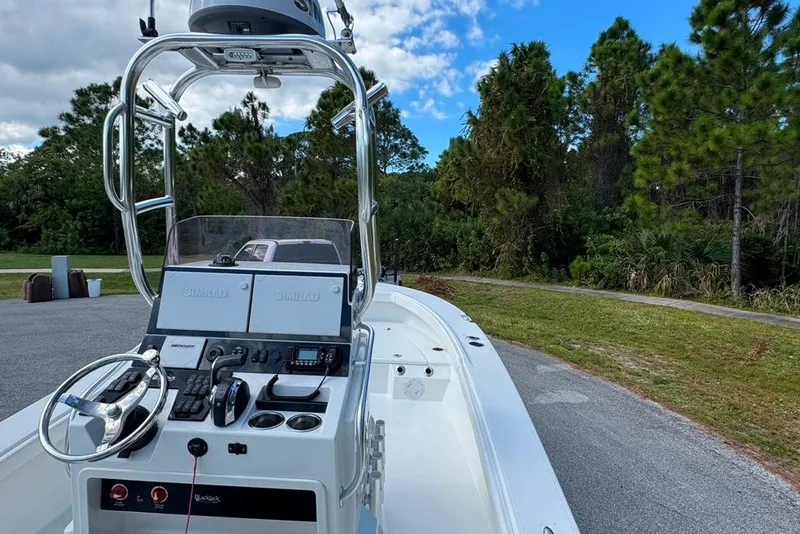 Slide: The Image of 2021 BlackJack 256 Coastal boat with advanced navigation system, parked near lush greenery. - 30