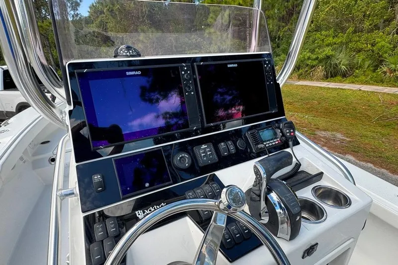 Slide: The Image of 2021 BlackJack 256 Coastal boat dashboard with dual Simrad displays and controls. - 32