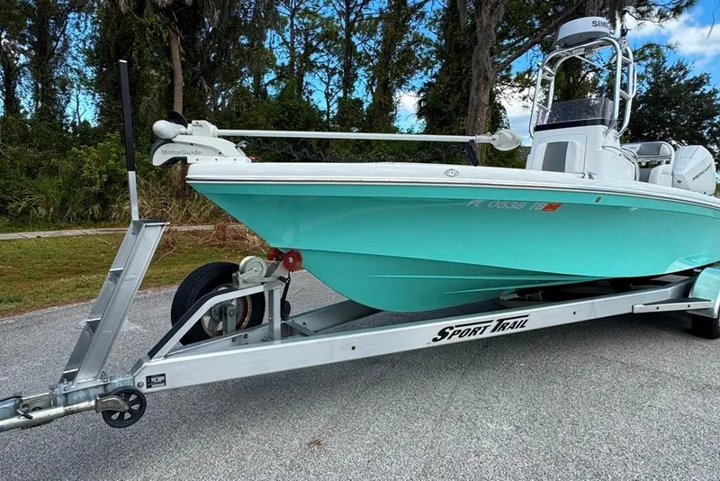 Slide: The Image of 2021 BlackJack 256 Coastal boat on trailer, turquoise hull, parked outdoors. - 6