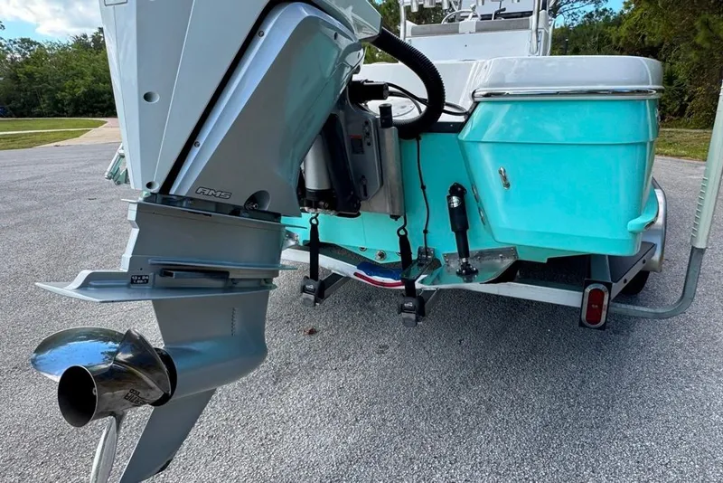 Slide: The Image of 2021 BlackJack 256 Coastal boat with outboard motor on trailer, parked on pavement. - 9