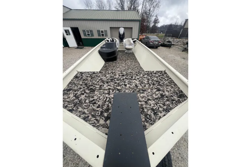 Slide: The Image of 2001 SeaArk 2272 MV boat with camouflage interior, parked outdoors near a building. - 6